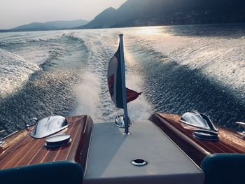 Deck chairs on table by sea against sky