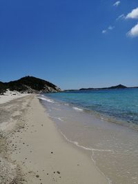 Scenic view of beach against blue sky