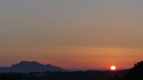 Scenic view of silhouette trees against orange sky