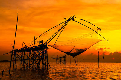 Fishing net against sky during sunset