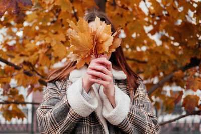 Woman holding autumn leaves