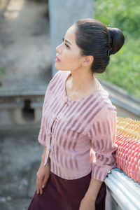 High angle view of woman standing by railing on staircase