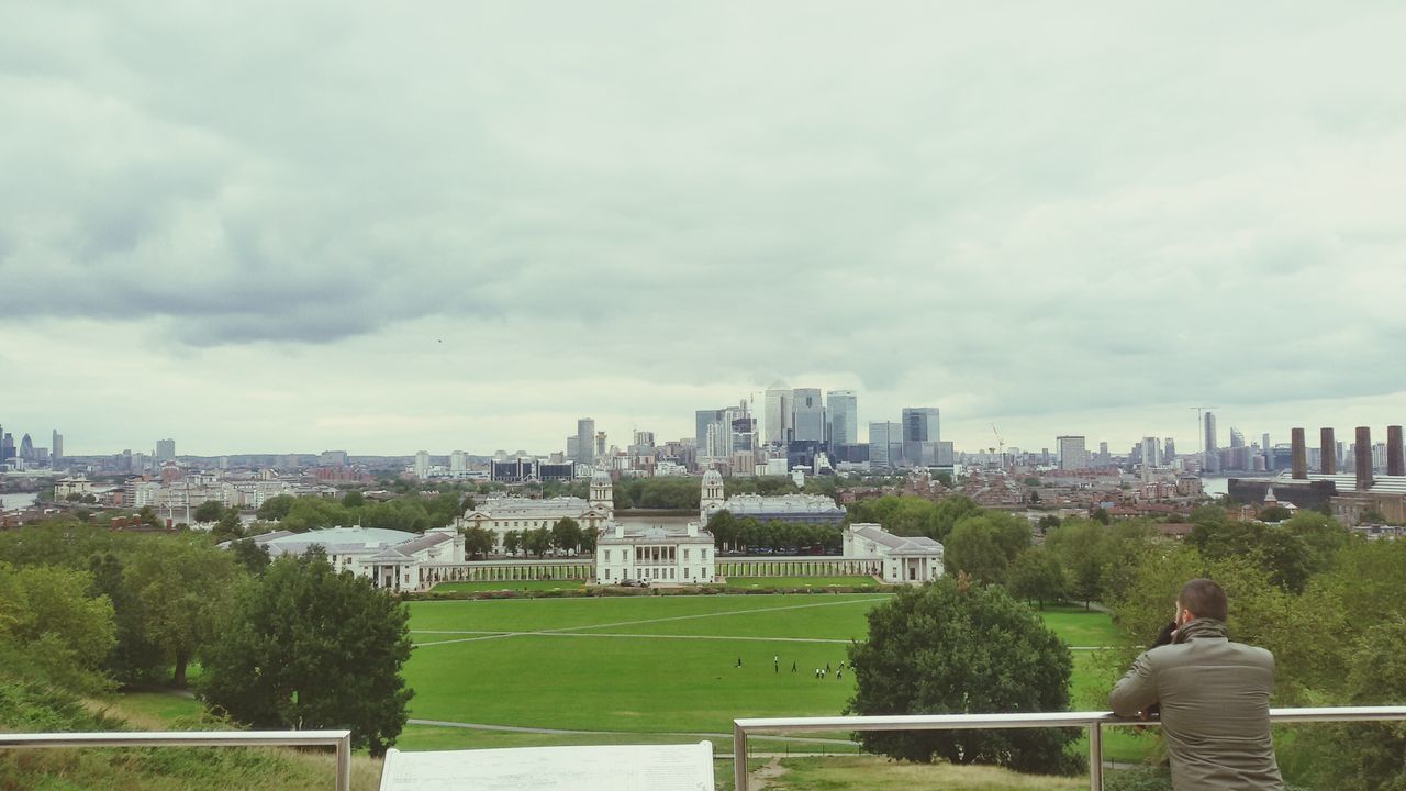 building exterior, sky, architecture, built structure, city, tree, cloud - sky, grass, cityscape, cloud, cloudy, men, park - man made space, green color, day, city life, skyscraper, lifestyles, lawn