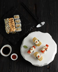 Japanese cuisine california roll, tamago sushi, and tuna roll on black wooden 