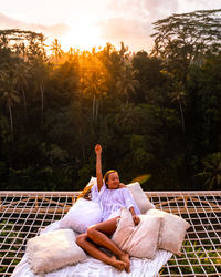 A girl lying in a net in the morning above the jungle in bali