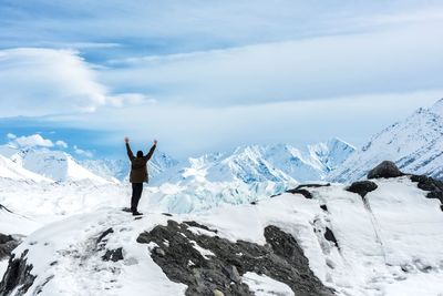 Rear view of man standing on snowy mountain