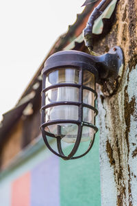 Low angle view of electric lamp hanging on wall