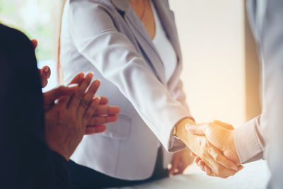 Business people giving handshake in meeting at office