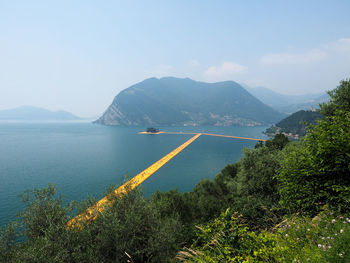 Scenic view of sea and mountains against sky