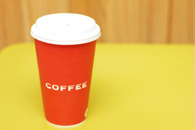 Close-up of coffee cup on yellow table