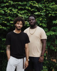 Portrait of friends standing against plants