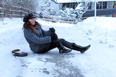 Young woman sitting on snow covered ice