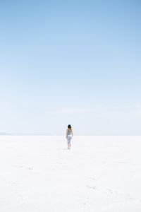 Rear view of man on landscape against clear sky