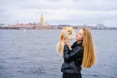 Lifestyle image of happy attractive young woman in black leather jacket walking