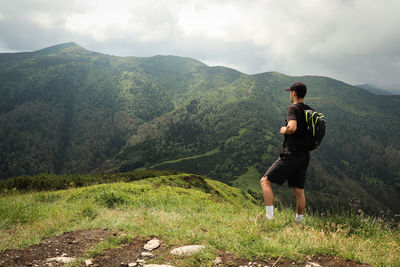 Athlete in a black t-shirt poses on top of the mala fatra mountain. climbing mount hromova. a hiker