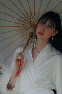 Portrait of young woman holding umbrella