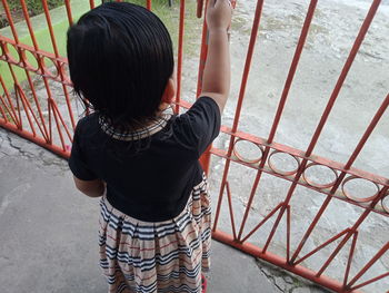 Rear view of boy standing on metal