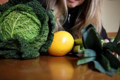 High angle view of woman with vegetables on table