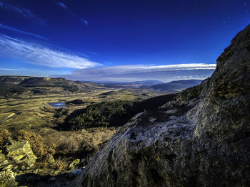 Scenic view of mountains against blue sky