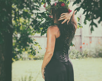 Side view of wet woman with long hair standing outdoors