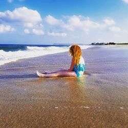 Full length of boy on beach against sky