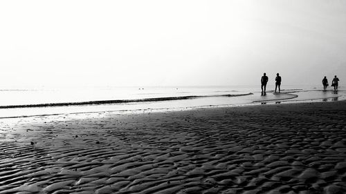 People on beach against sky