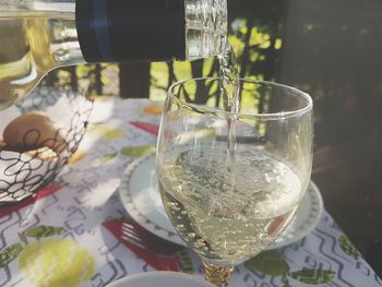 Close-up of wine being poured into glass on table