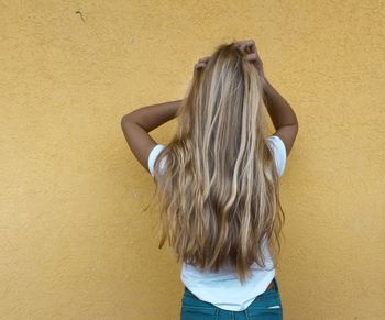 Rear view of woman standing on tiled floor