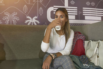 Woman drinking coffee in store cafe paramo, a new coffee shop chain in simon bolivar airport