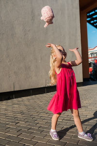 Full length of young woman standing against wall