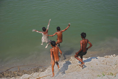 Rear view of people enjoying on beach