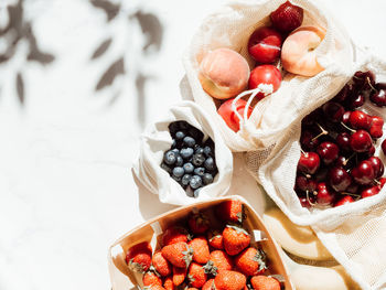 Fresh berries in bags and box on the table in sunlight. purchases made at the local store on  table