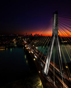 Illuminated bridge and cityscape against sky at night