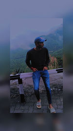 Man standing on mountain against sky