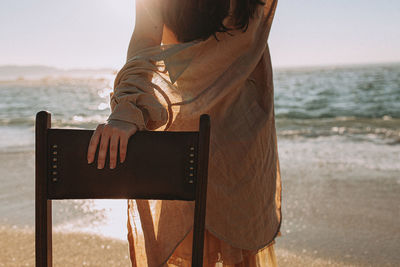 Rear view of woman standing at beach