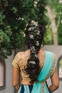 Rear view of woman standing against tree