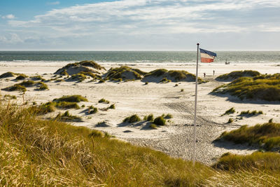 Flag at beach against sky