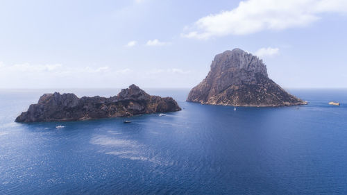 Rock formation in sea against sky