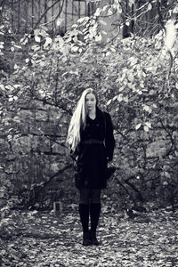 Full length portrait of woman standing in forest