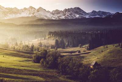 Scenic view of field and mountains against sky