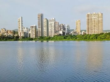 City buildings by sea against sky