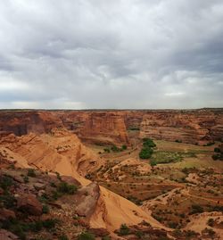 Scenic view of rocky mountains at canyon de chelly national park against cloudy sky