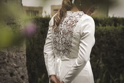 Midsection of bride standing in park