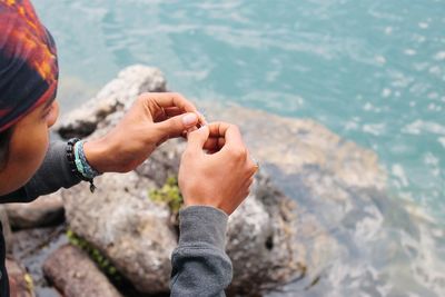 High angle view of man hand on rock