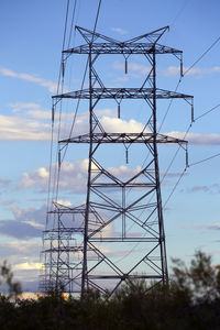 Electricity pylon against cloudy sky