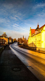 View of city street against cloudy sky