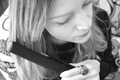 Close-up of woman using hair straightener