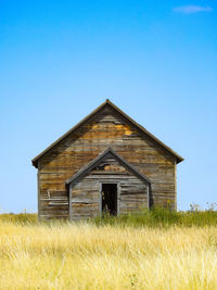 Front view of an old abandoned one-room house on a hill on the oklahoma prairie