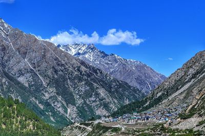 High angle view of snowcapped mountains against blue sky