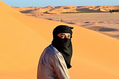 Mid adult man in desert against sky